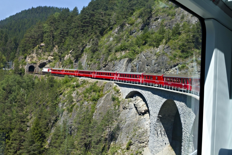 Train Glacier Express suisse sur un viaduc à l'entrée d'un tunnel, vu de l'intérieur du train